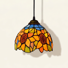 Heliette, 6-8 Inch - Blue Tiffany-style stained glass pendant light, lit, on a plain ivory studio background