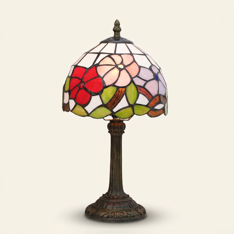 Trielle 8 Inch Tiffany-style stained glass table lamp, lit, on a plain ivory studio background