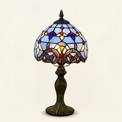 Bellamont 8 Inch Tiffany-style stained glass table lamp, Curved Pole base, lit, on a plain ivory studio background
