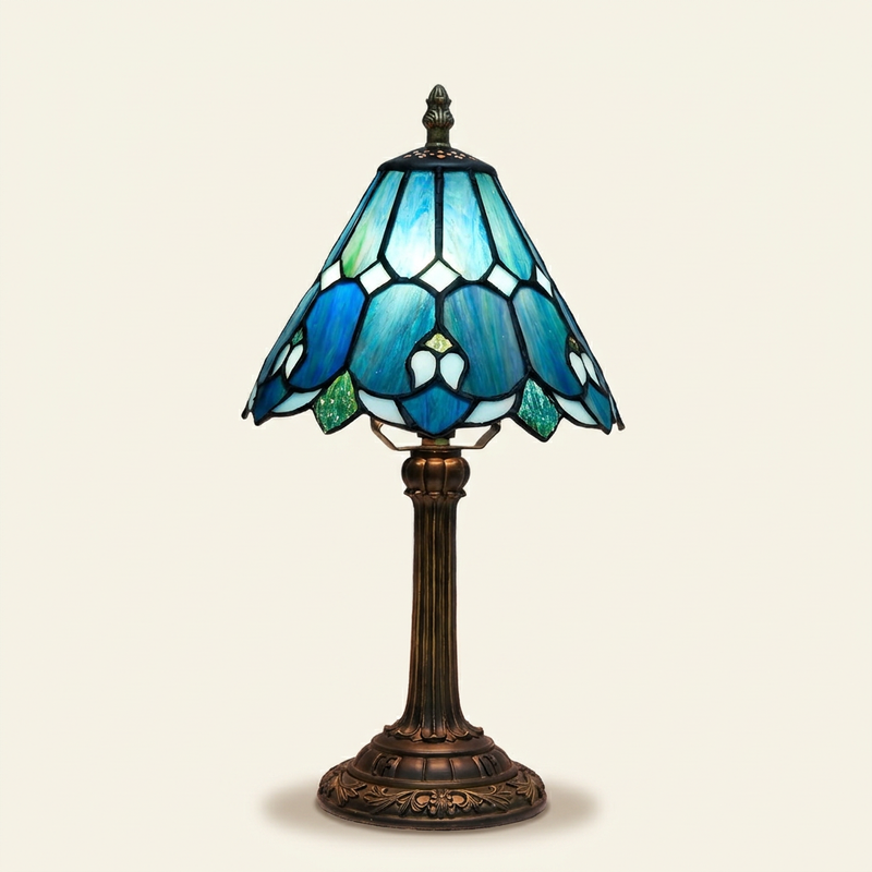 Azuria Blue 8 Inch Tiffany-style stained glass table lamp, lit, on a plain ivory studio background