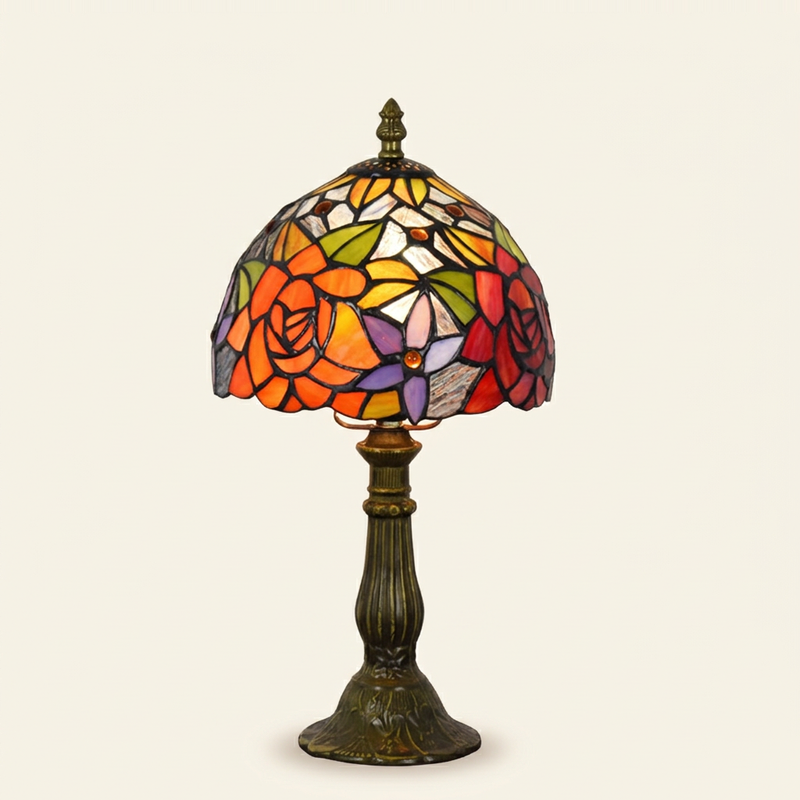 Amberose 8 Inch Tiffany-style stained glass table lamp, lit, on a plain ivory studio background