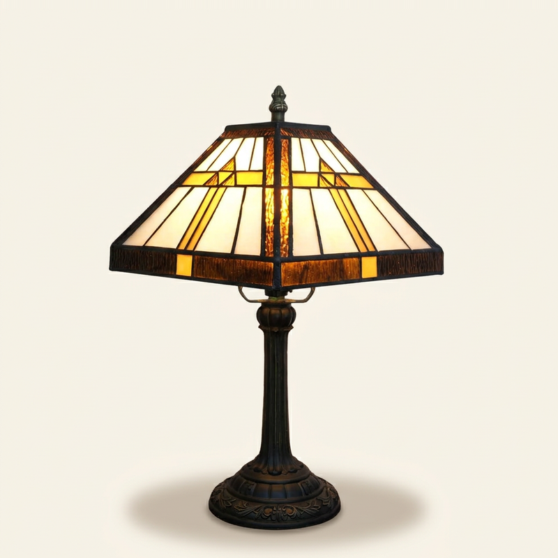 Trigona 11 Inch Tiffany-style stained glass table lamp, lit, on a plain ivory studio background