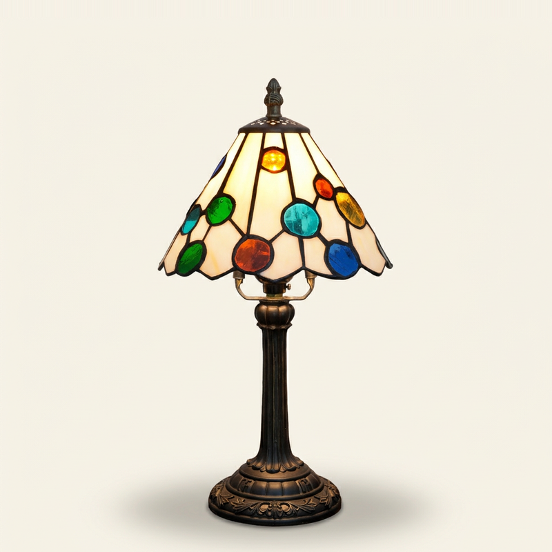 Bellamy 8 Inch Tiffany-style stained glass table lamp, lit, on a plain ivory studio background