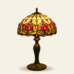 Tulira 12 Inch Tiffany-style stained glass table lamp, Curved Pole base, lit, on a plain ivory studio background