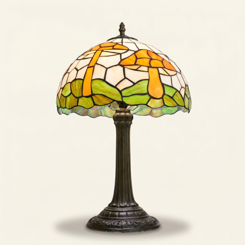 Amanita 12 Inch Tiffany-style stained glass table lamp, lit, on a plain ivory studio background