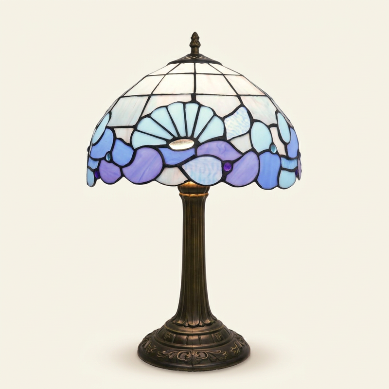 Nautilla 12 Inch Tiffany-style stained glass table lamp, lit, on a plain ivory studio background