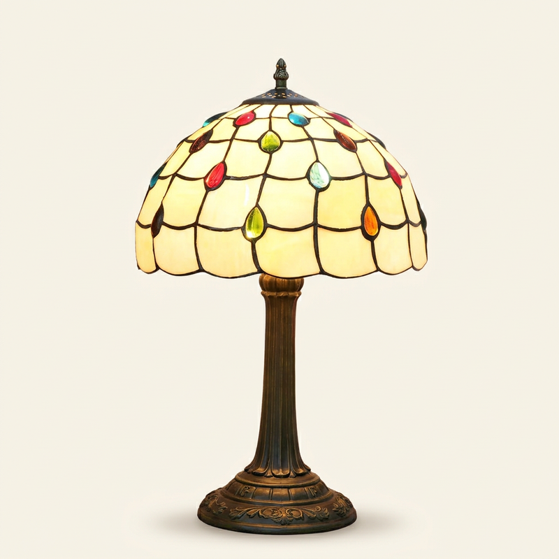 Ambrette 12 Inch Tiffany-style stained glass table lamp, lit, on a plain ivory studio background