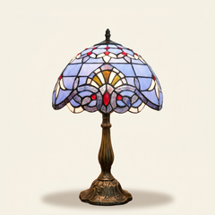 Bellamont 12 Inch Tiffany-style stained glass table lamp, Curved Pole base, lit, on a plain ivory studio background