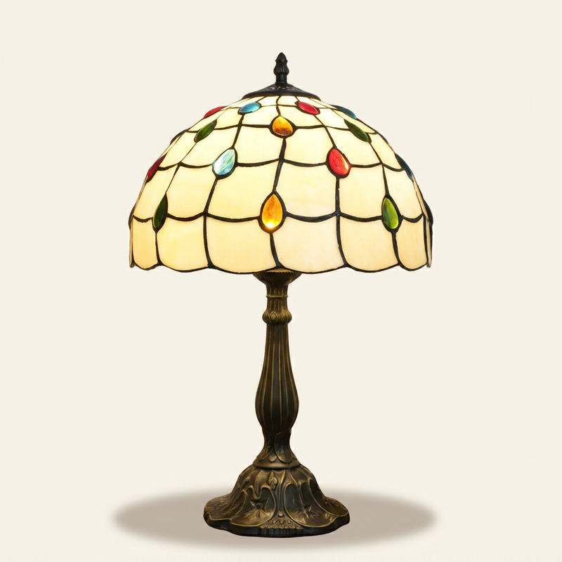 Fioretta 12 Inch Tiffany-style stained glass table lamp, lit, on a plain ivory studio background