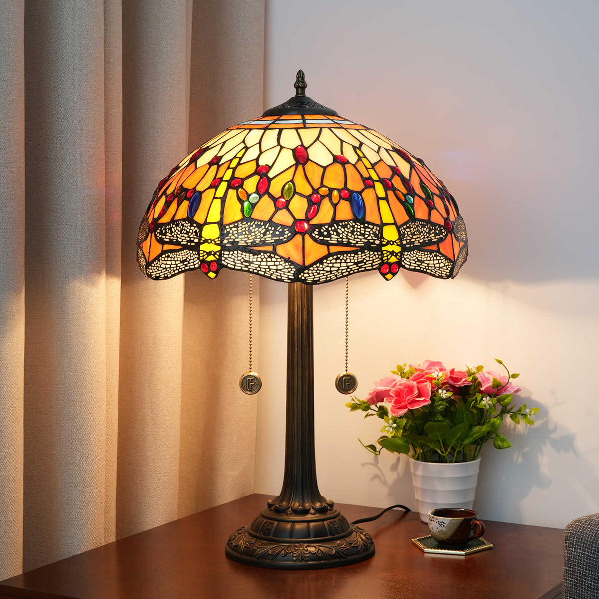 Dragonfly with Orange Bottom Lamp - lit on nightstand with book