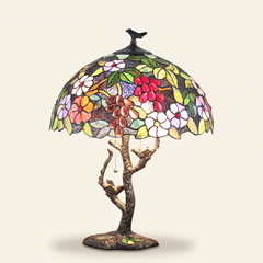 Muscadelle 16 Inch Tiffany-style stained glass table lamp, Branch Pole base, lit, on a plain ivory studio background