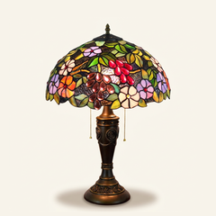 Muscadelle 16 Inch Tiffany-style stained glass table lamp, Rose Pole base, lit, on a plain ivory studio background