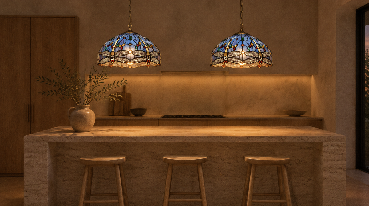 Two Zephyrine 16 inch dragonfly pendants lit over a travertine kitchen island